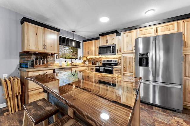 kitchen featuring a sink, tasteful backsplash, light brown cabinets, appliances with stainless steel finishes, and hanging light fixtures