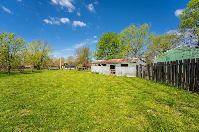 view of yard featuring an exterior structure, a pole building, an outbuilding, and fence