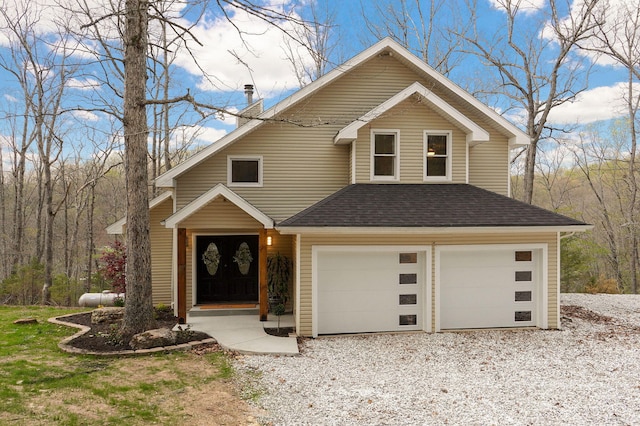 view of front of property with a chimney, driveway, roof with shingles, and a garage