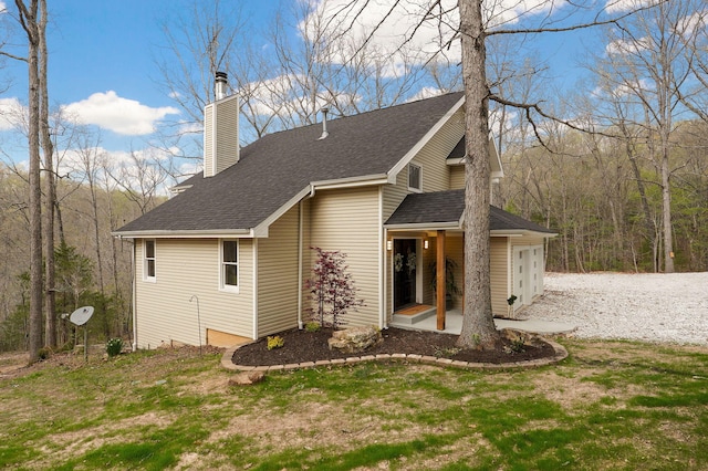 view of home's exterior with an attached garage, a chimney, and roof with shingles