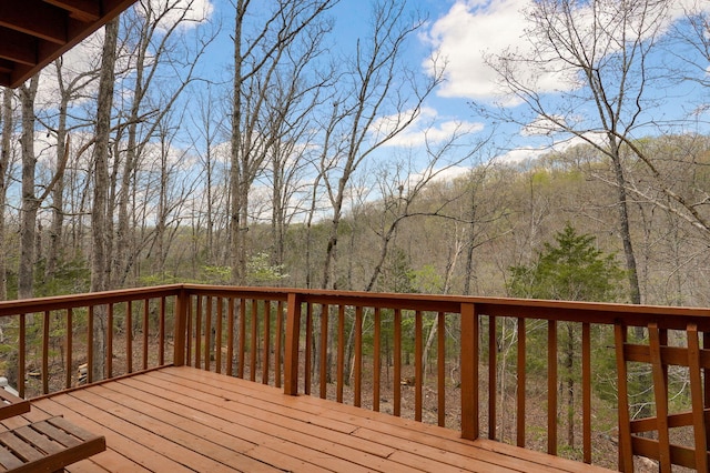 wooden terrace featuring a view of trees