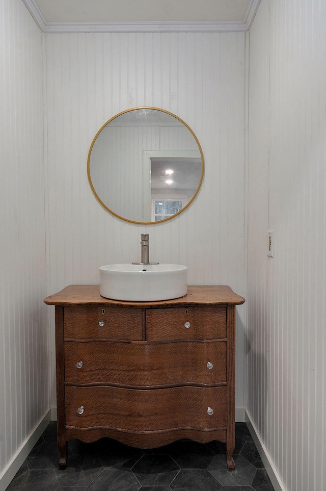 bathroom featuring wooden walls, baseboards, and vanity