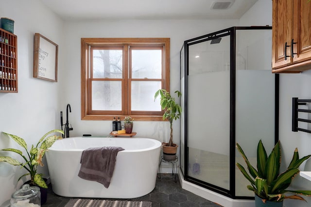 bathroom with a freestanding tub, visible vents, and a stall shower