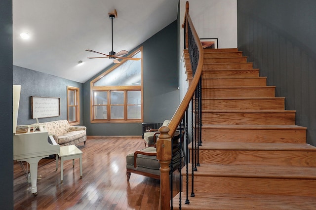 stairs with hardwood / wood-style flooring, ceiling fan, and vaulted ceiling
