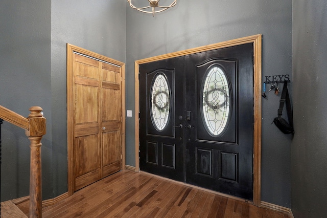 entrance foyer featuring baseboards, wood finished floors, and stairs