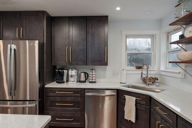 kitchen featuring open shelves, a sink, dark brown cabinetry, appliances with stainless steel finishes, and recessed lighting