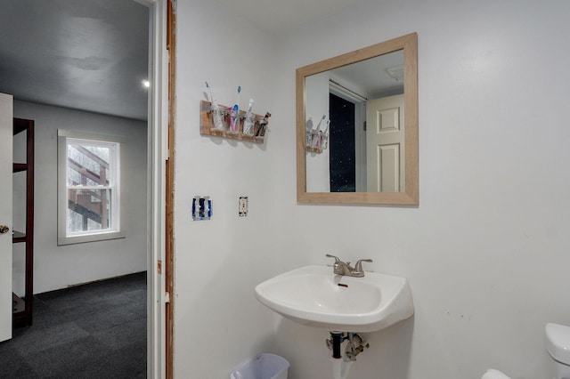 half bathroom featuring a sink and toilet