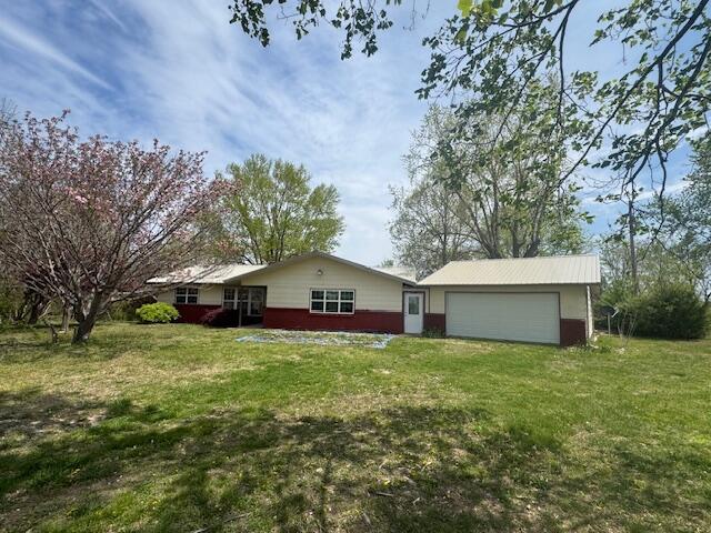 back of house with a yard and a garage