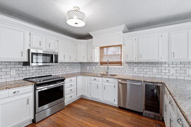 101 Poindexter Dr, Pineville, MO 64856 - kitchen with a sink, a textured ceiling, beverage cooler, white cabinets, and appliances with stainless steel finishes