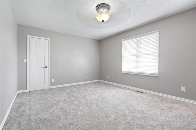 101 Poindexter Dr, Pineville, MO 64856 - carpeted empty room with ceiling fan, baseboards, a textured ceiling, and visible vents