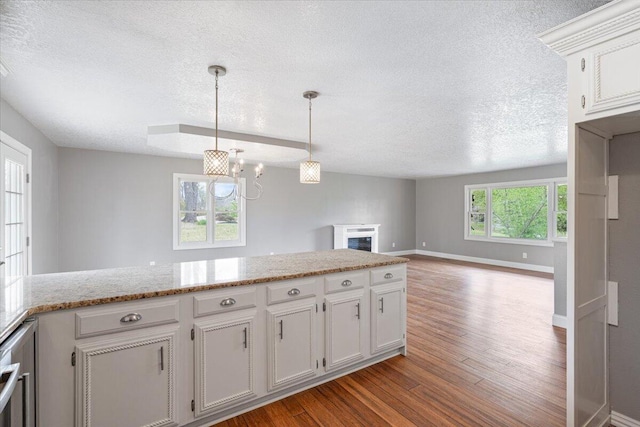 101 Poindexter Dr, Pineville, MO 64856 - kitchen with wood finished floors, a textured ceiling, baseboards, and a notable chandelier