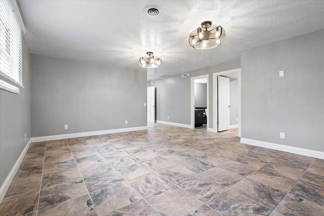 101 Poindexter Dr, Pineville, MO 64856 - spare room with stone finish floor, a textured ceiling, baseboards, and visible vents
