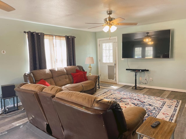 living room featuring ceiling fan, baseboards, and wood finished floors