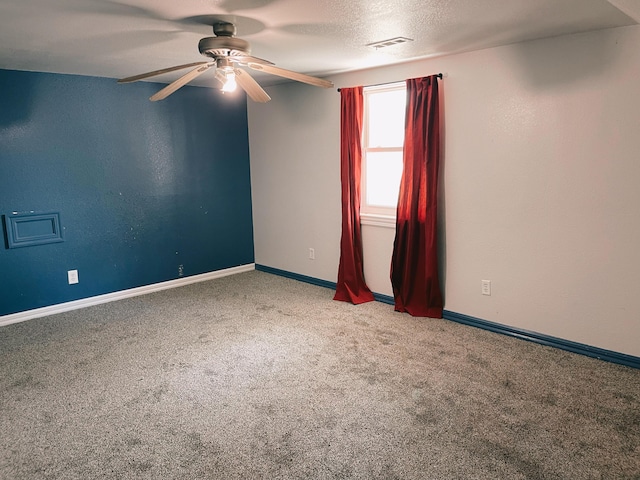 carpeted spare room featuring visible vents, baseboards, and ceiling fan