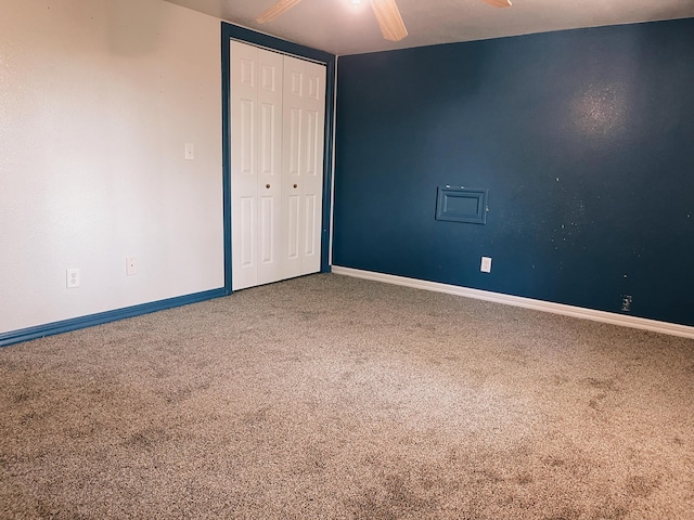 unfurnished bedroom featuring baseboards, carpet, and a closet