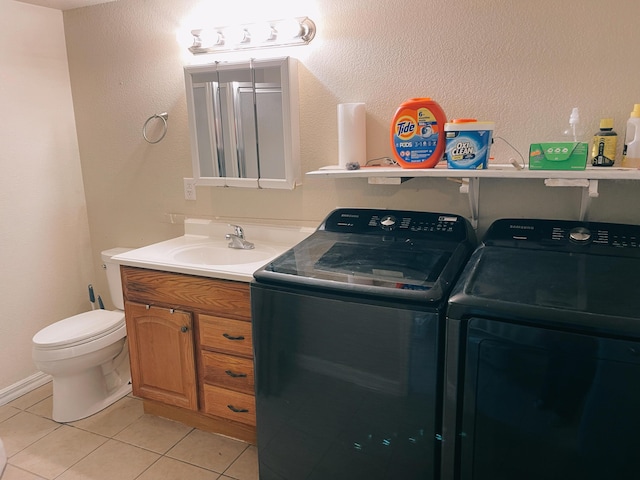 laundry area with washing machine and clothes dryer, light tile patterned flooring, a sink, and laundry area