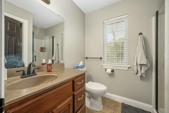 bathroom featuring toilet, tile patterned floors, a stall shower, vanity, and baseboards
