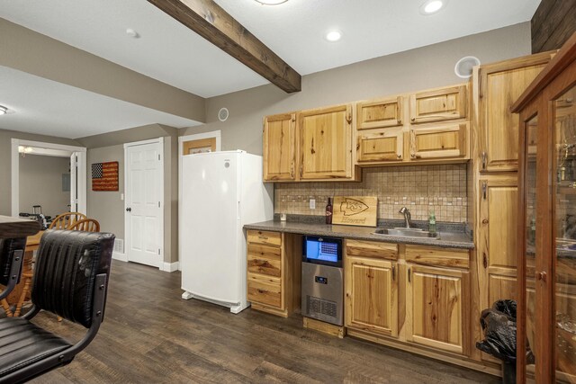 kitchen featuring a sink, dark countertops, freestanding refrigerator, backsplash, and beamed ceiling