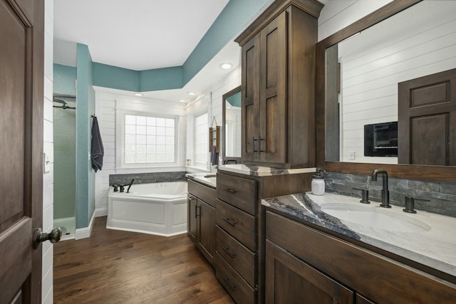 full bathroom featuring a garden tub, wood finished floors, vanity, and tiled shower