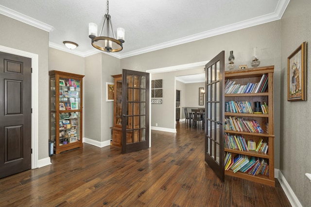interior space featuring crown molding, wood finished floors, an inviting chandelier, french doors, and baseboards