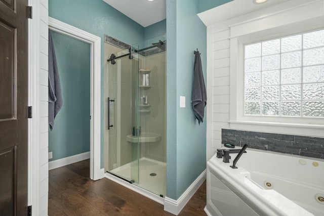 full bath with baseboards, a shower stall, a tub with jets, and wood finished floors