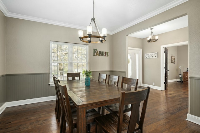 dining space featuring dark wood finished floors, an inviting chandelier, ornamental molding, and baseboards