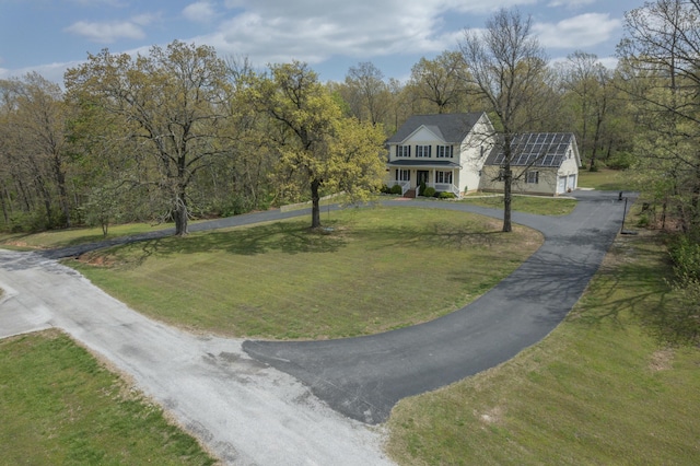 exterior space featuring a front lawn, driveway, and solar panels