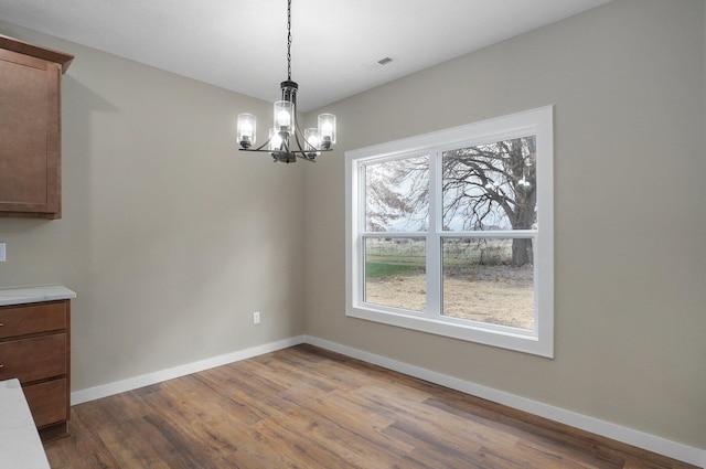 5464 Anita Ave, Pleasant Hope, MO 65725 - unfurnished dining area with a chandelier, healthy amount of natural light, and dark wood-type flooring