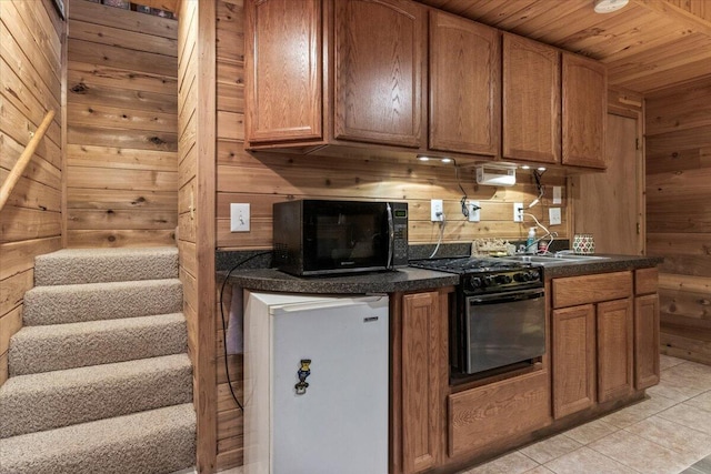 7745 Murr Rd, Graff, MO 65660 - kitchen with wooden walls, dark countertops, a sink, and black appliances