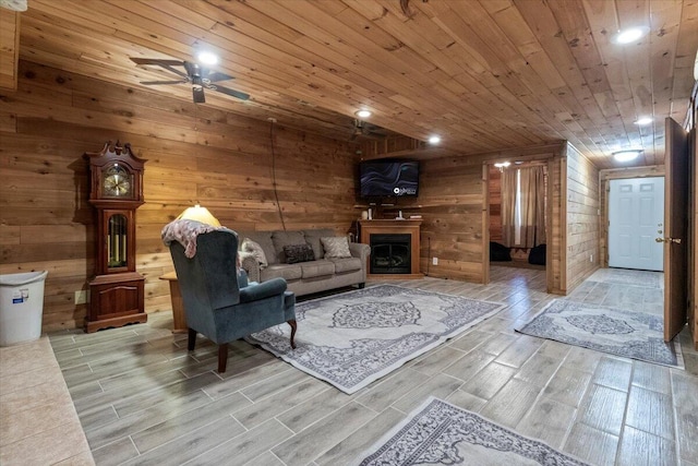 7745 Murr Rd, Graff, MO 65660 - living area with ceiling fan, wood ceiling, wooden walls, wood tiled floor, and a fireplace