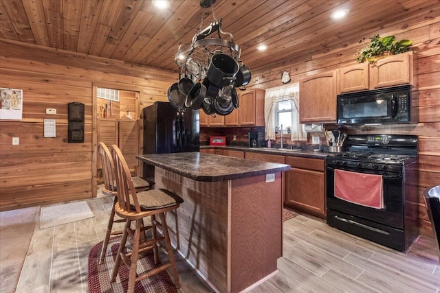 7745 Murr Rd, Graff, MO 65660 - kitchen featuring dark countertops, a center island, black appliances, a breakfast bar area, and wooden ceiling
