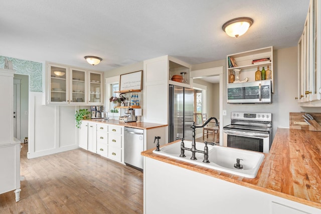 344 Zinnia Ln, Kirbyville, MO 65679 - kitchen featuring appliances with stainless steel finishes, open shelves, a sink, light wood-style flooring, and white cabinets
