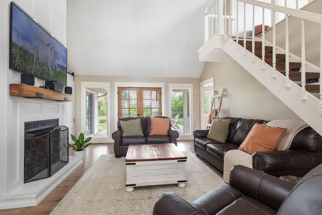 344 Zinnia Ln, Kirbyville, MO 65679 - living area featuring stairway, wood finished floors, a fireplace with raised hearth, french doors, and high vaulted ceiling
