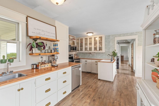344 Zinnia Ln, Kirbyville, MO 65679 - kitchen featuring appliances with stainless steel finishes, open shelves, a sink, light wood finished floors, and wallpapered walls