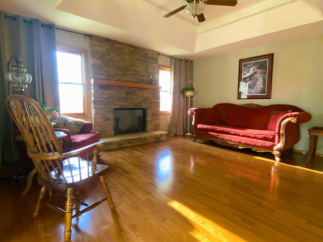 6475 S Farm Rd Unit 193, Rogersville, MO 65742 - living area featuring plenty of natural light, a tray ceiling, wood finished floors, and ceiling fan