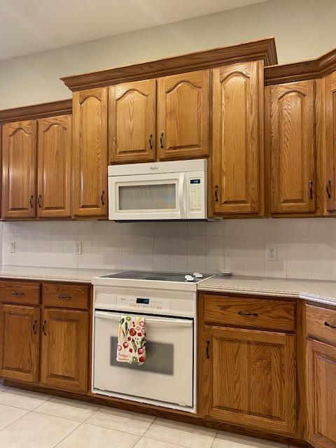 4822 S Montrose Pl, Springfield, MO 65810 - kitchen featuring light countertops, white appliances, brown cabinets, and tasteful backsplash