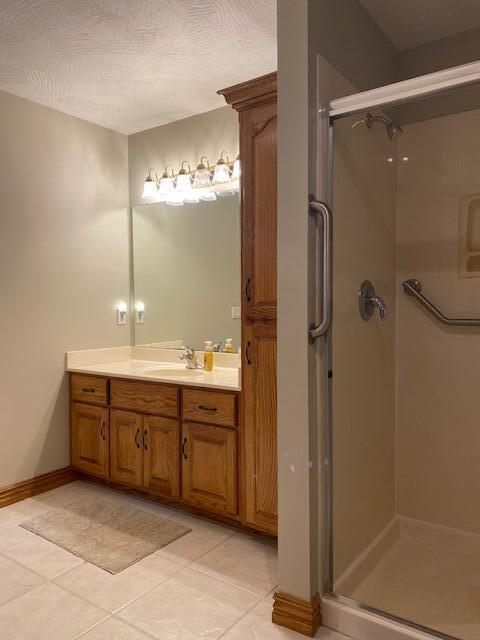 4822 S Montrose Pl, Springfield, MO 65810 - full bath featuring baseboards, a shower stall, tile patterned flooring, and vanity