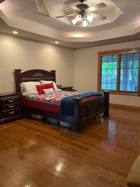 4822 S Montrose Pl, Springfield, MO 65810 - bedroom featuring ceiling fan, a tray ceiling, wood finished floors, and recessed lighting