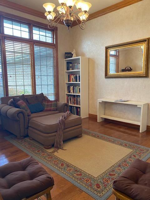 4822 S Montrose Pl, Springfield, MO 65810 - living area with wood finished floors, an inviting chandelier, ornamental molding, and a healthy amount of sunlight