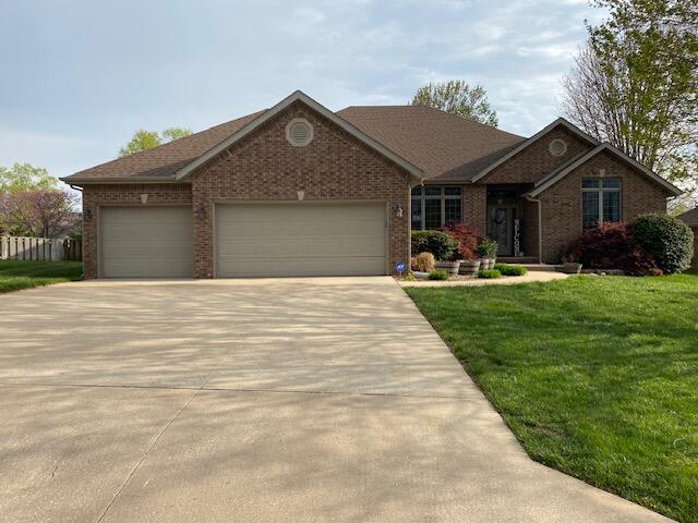 4822 S Montrose Pl, Springfield, MO 65810 - ranch-style house with concrete driveway, a front lawn, brick siding, and a garage