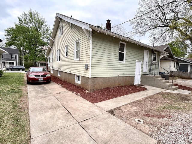 535 E Normal St, Springfield, MO 65807 - view of home's exterior with a chimney and concrete driveway