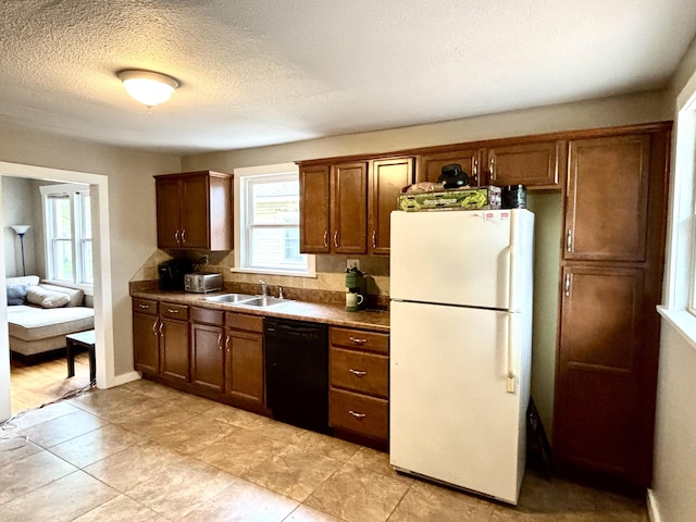535 E Normal St, Springfield, MO 65807 - kitchen with freestanding refrigerator, dishwasher, a textured ceiling, brown cabinets, and dark countertops
