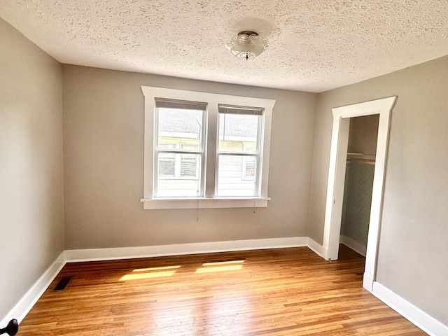 535 E Normal St, Springfield, MO 65807 - unfurnished bedroom with light wood-style flooring, a textured ceiling, and a closet