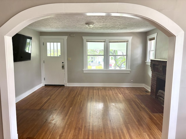 535 E Normal St, Springfield, MO 65807 - unfurnished living room with healthy amount of natural light, wood-type flooring, and arched walkways
