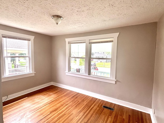 535 E Normal St, Springfield, MO 65807 - unfurnished room featuring wood finished floors and a textured ceiling