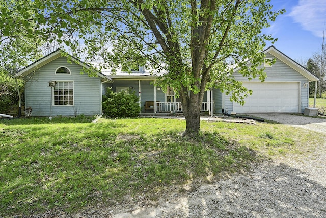 ranch-style home with an attached garage, gravel driveway, covered porch, and a front yard