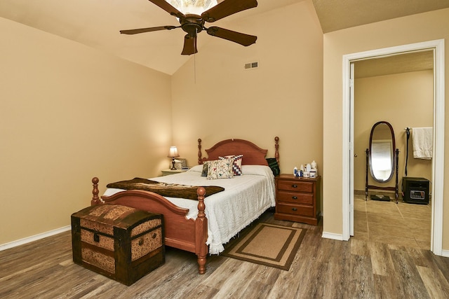 bedroom with baseboards, visible vents, lofted ceiling, a ceiling fan, and wood finished floors
