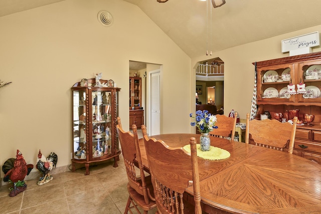 dining room with a ceiling fan, vaulted ceiling, light tile patterned flooring, and visible vents