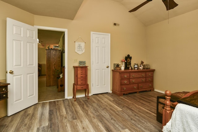 bedroom featuring lofted ceiling, wood finished floors, visible vents, a ceiling fan, and baseboards