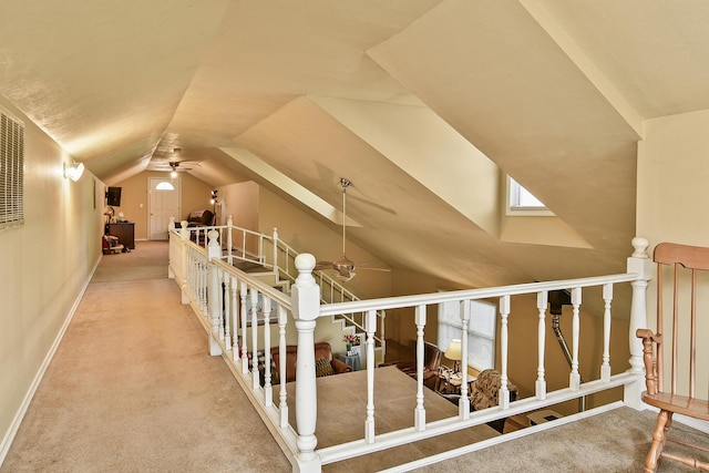 additional living space with a ceiling fan, baseboards, carpet, and vaulted ceiling with skylight